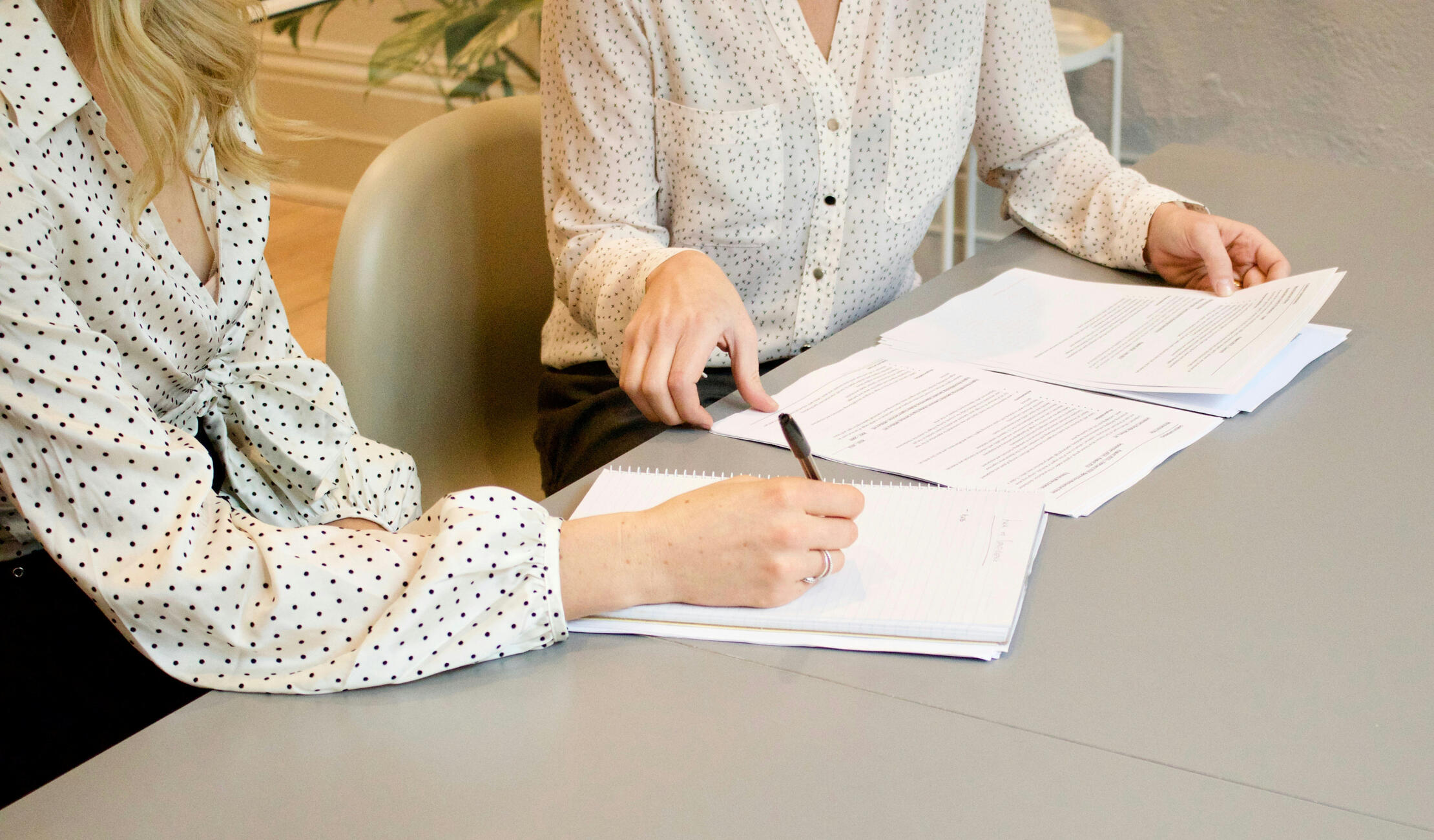 Two at a desk taking notes.